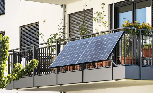 Solar panel mounted on an apartment balcony railing, surrounded by potted plants and flowers, providing renewable energy for the home.